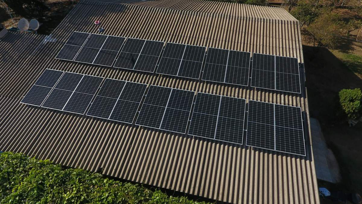 Painéis solares instalados sobre telhado de telha metálica.